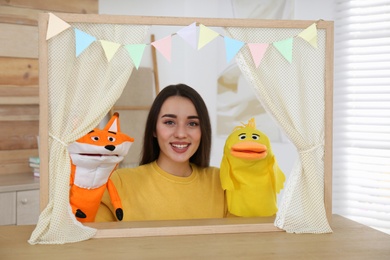Young woman performing puppet show at home