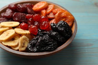 Photo of Mix of delicious dried fruits on light blue wooden table, closeup