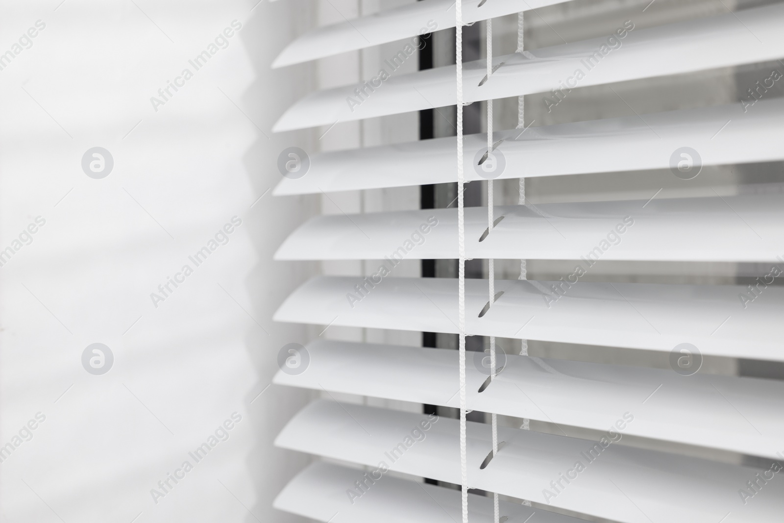 Photo of Stylish window with horizontal blinds, closeup view
