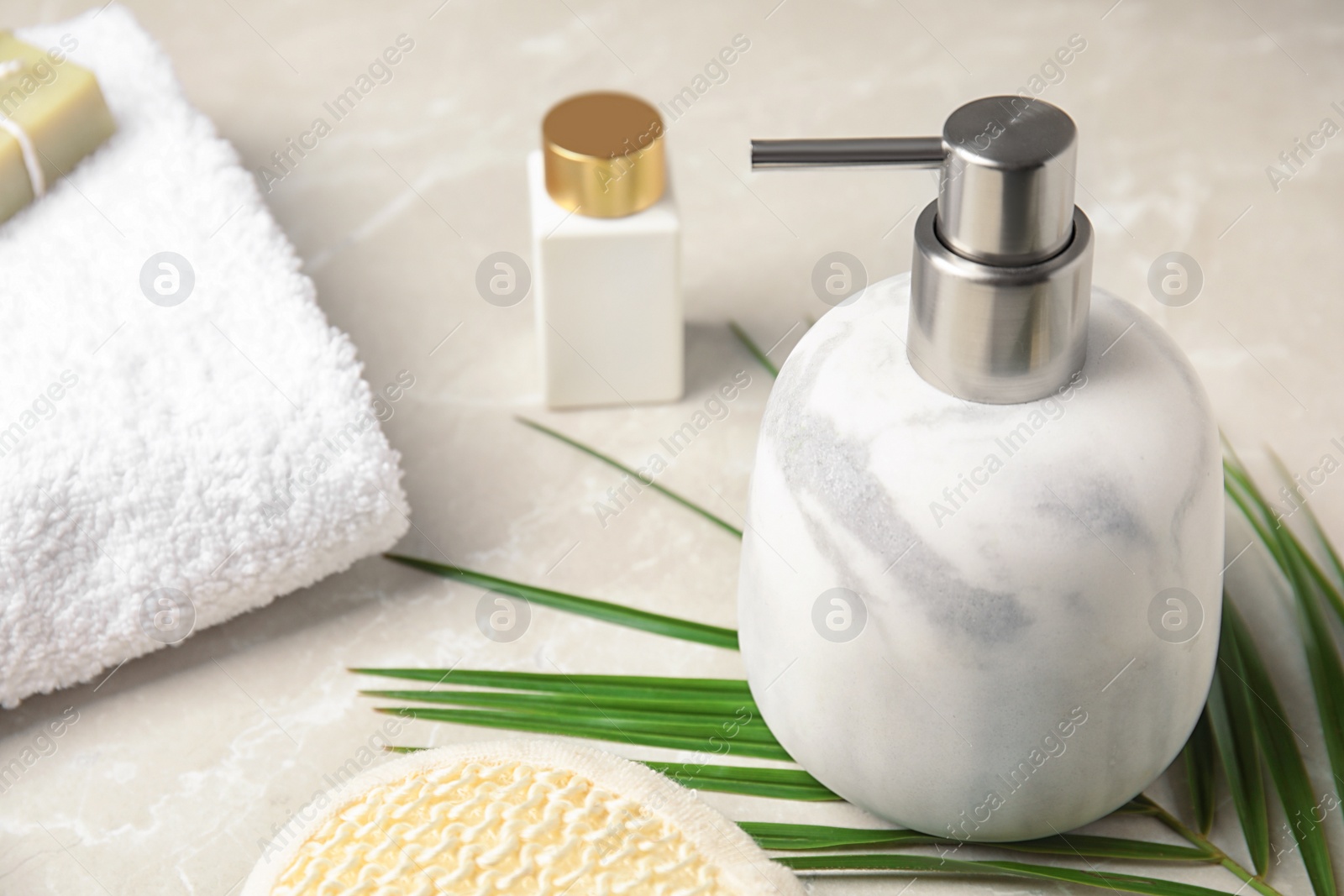 Photo of Modern marble soap dispenser on light table