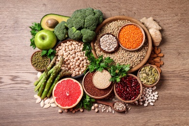 Photo of Fresh vegetables, fruits and seeds on wooden table, flat lay