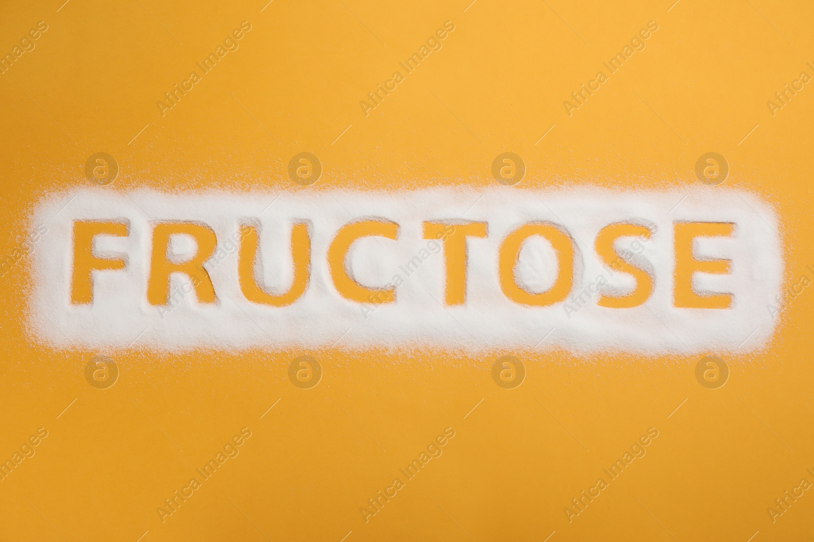 Photo of Word Fructose made of sugar on orange background, top view