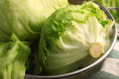 Photo of Fresh green clean iceberg lettuce heads and leaves in colander, closeup