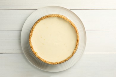 Tasty vegan tofu cheesecake on white wooden table, top view