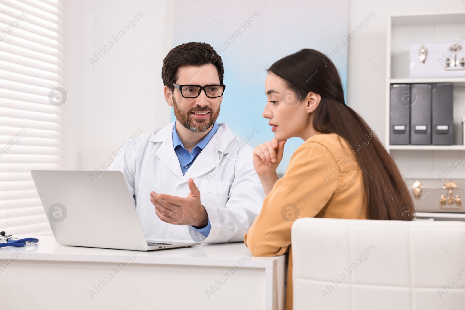 Photo of Doctor consulting patient during appointment in clinic