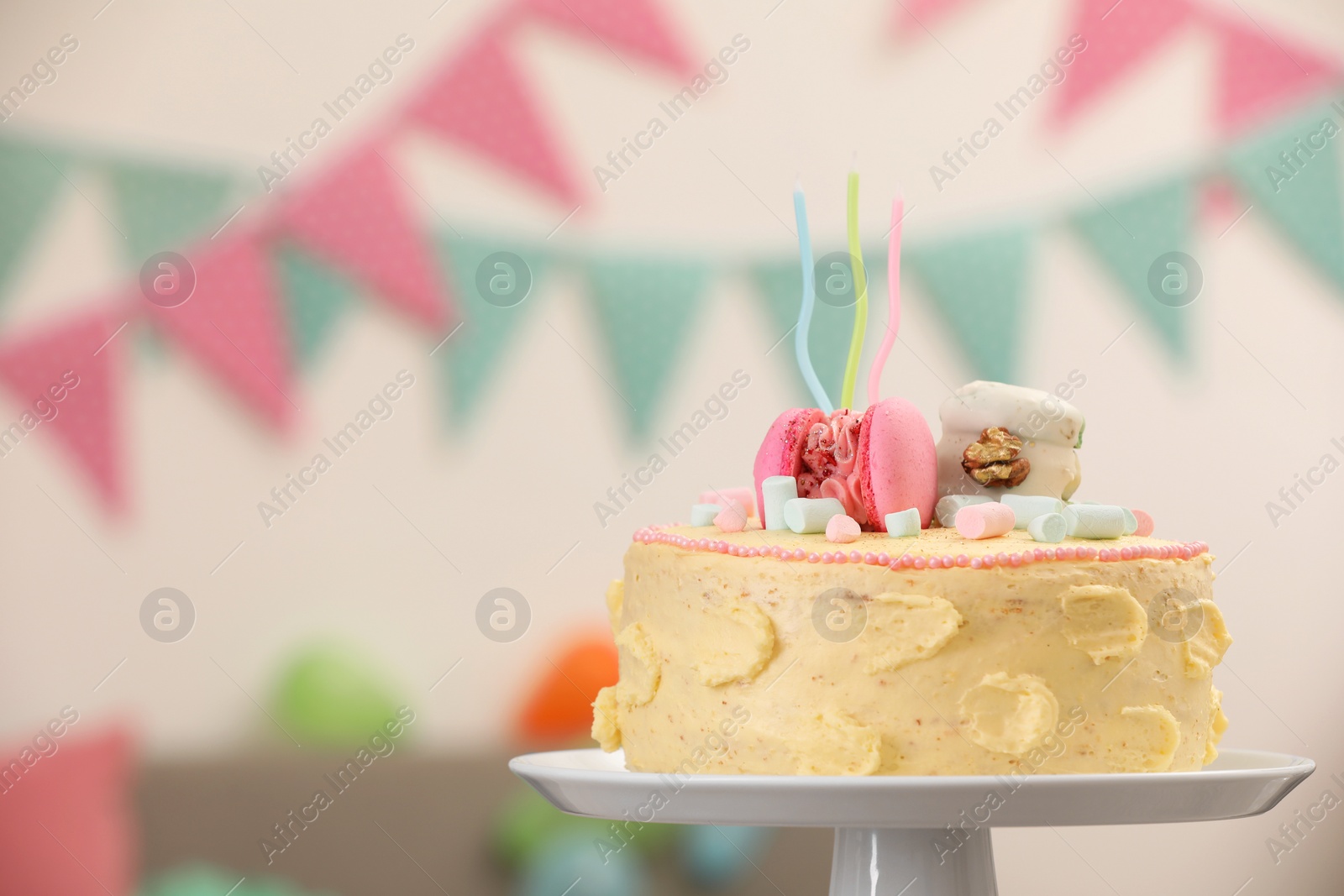 Photo of Delicious cake decorated with macarons and marshmallows against blurred background, space for text