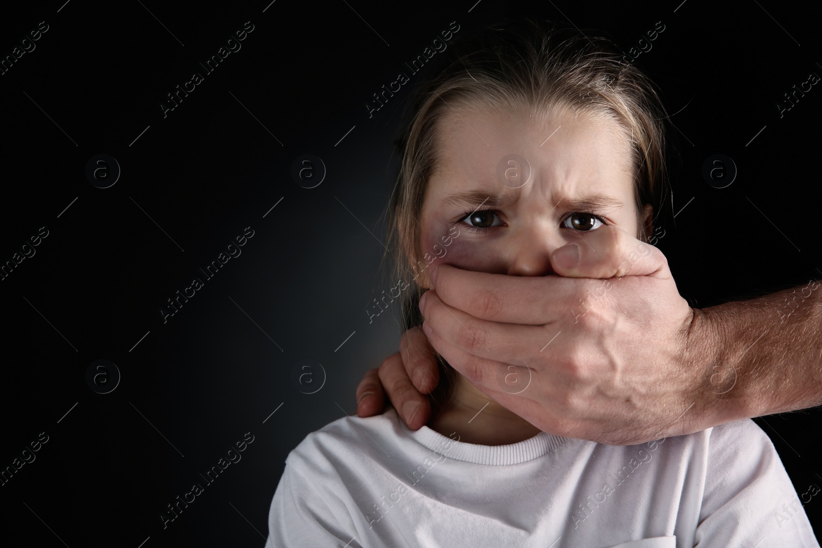 Photo of Man covering scared little girl's mouth on black background, space for text. Domestic violence