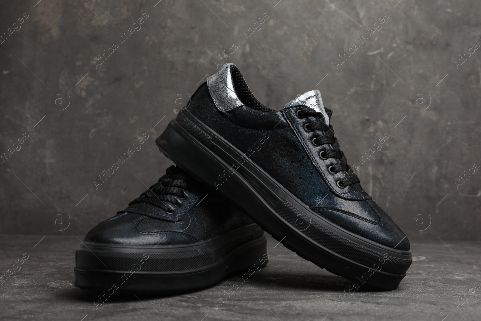 Photo of Stylish black shoes on grey stone table