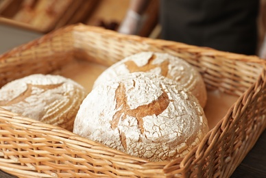 Wicker tray with fresh loaves of bread in bakery