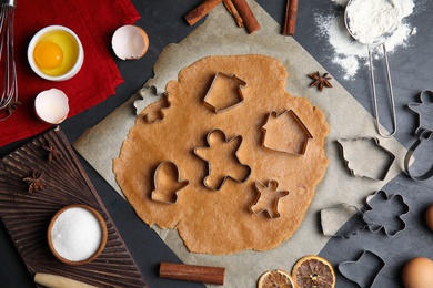 Photo of Raw dough, different cutters and ingredients for Christmas cookies on grey table, flat lay