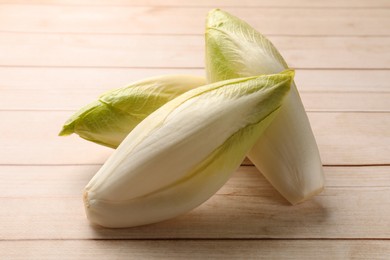 Photo of Raw ripe chicories on wooden table, closeup