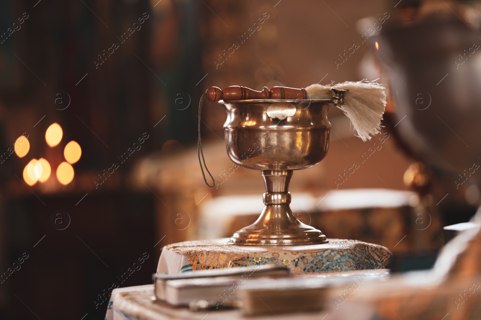 Photo of Silver vessel with holy water and brush on stand in church, space for text. Baptism ceremony