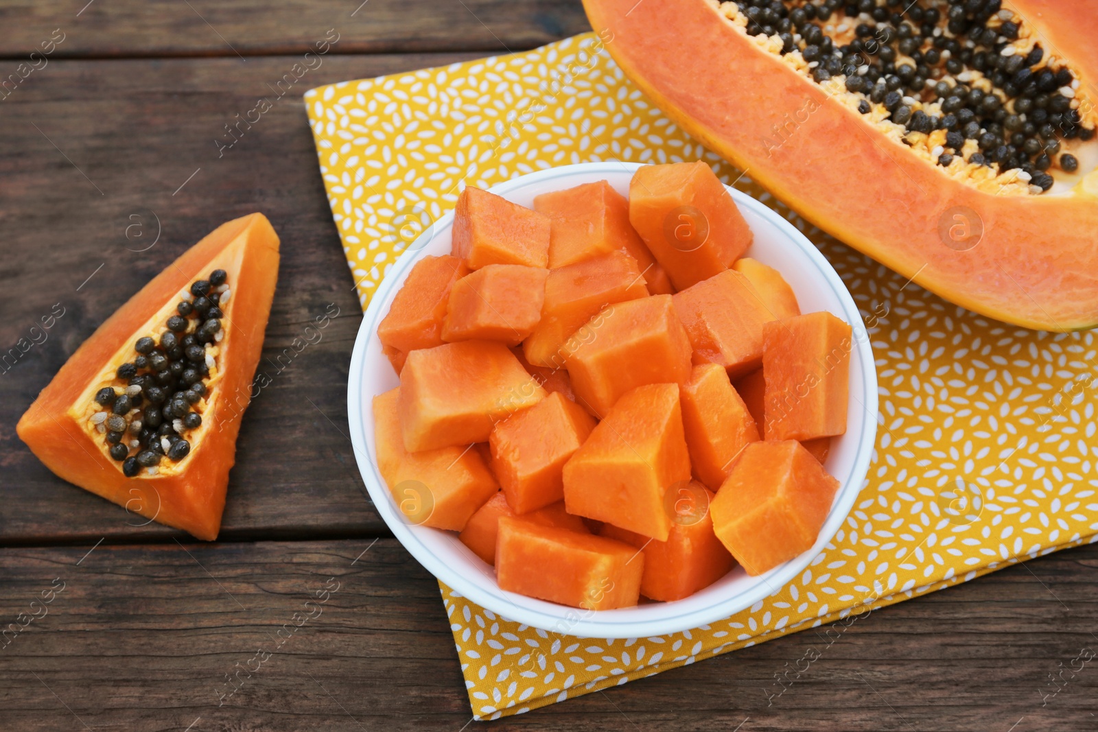 Photo of Tasty ripe cut papaya fruits on wooden table, above view