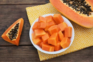 Photo of Tasty ripe cut papaya fruits on wooden table, above view