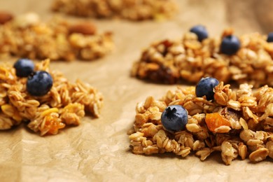 Different granola bars on parchment paper, closeup. Healthy snack
