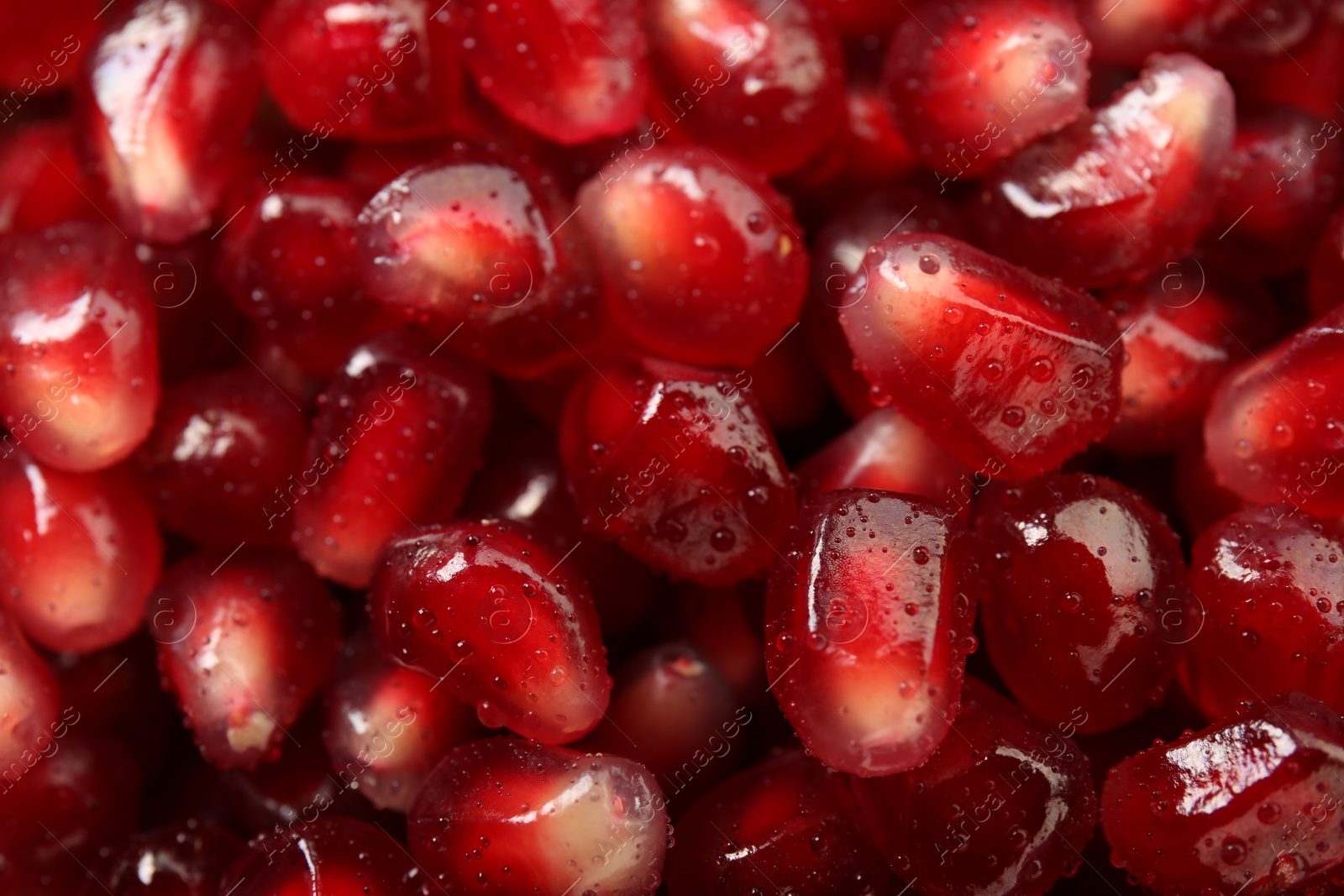 Photo of Ripe juicy pomegranate grains with water drops as background, top view