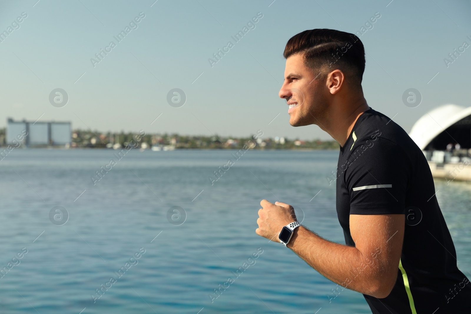 Photo of Man wearing modern smart watch during training near river