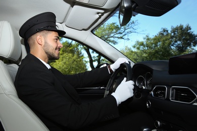 Young handsome driver in luxury car. Chauffeur service