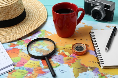 Photo of World map and different travel accessories on table. Planning summer vacation trip