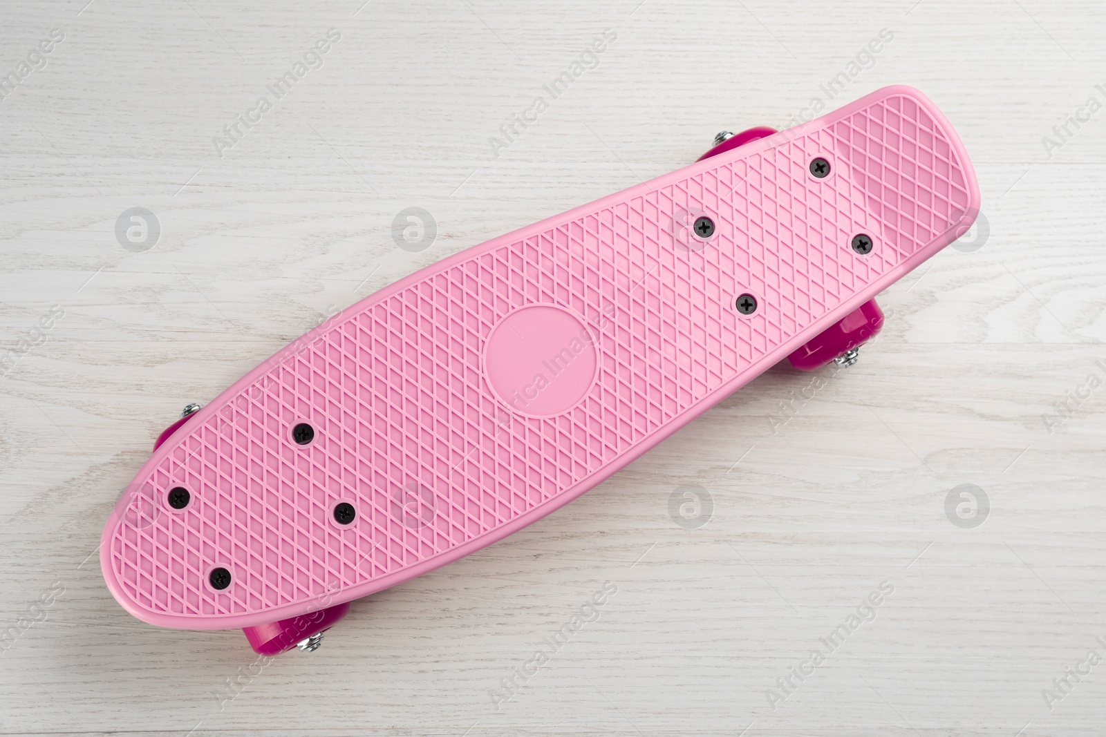 Photo of Pink skateboard on white wooden background, top view. Sport equipment