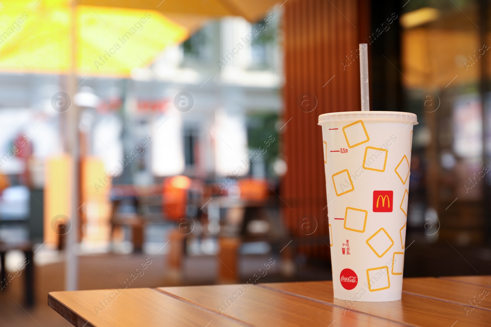 Photo of MYKOLAIV, UKRAINE - AUGUST 11, 2021: Cold McDonald's drink on table in cafe. Space for text