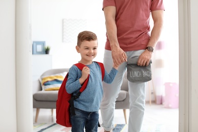 Young man taking his little child to school