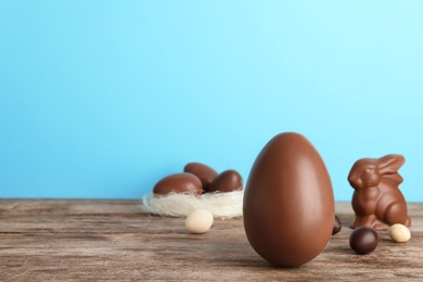 Photo of Beautiful composition with chocolate Easter egg on wooden table. Space for text