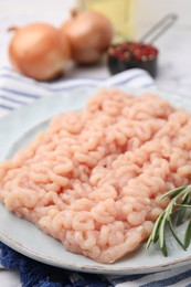 Fresh raw minced meat with rosemary on table, closeup