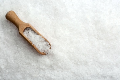 Photo of Natural salt and wooden scoop, top view. Space for text