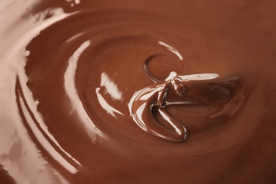 Photo of Delicious melted milk chocolate, closeup