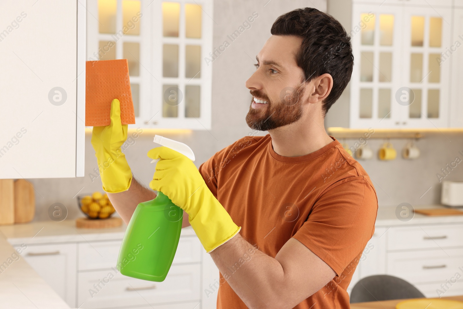 Photo of Spring cleaning. Man tidying up kitchen at home