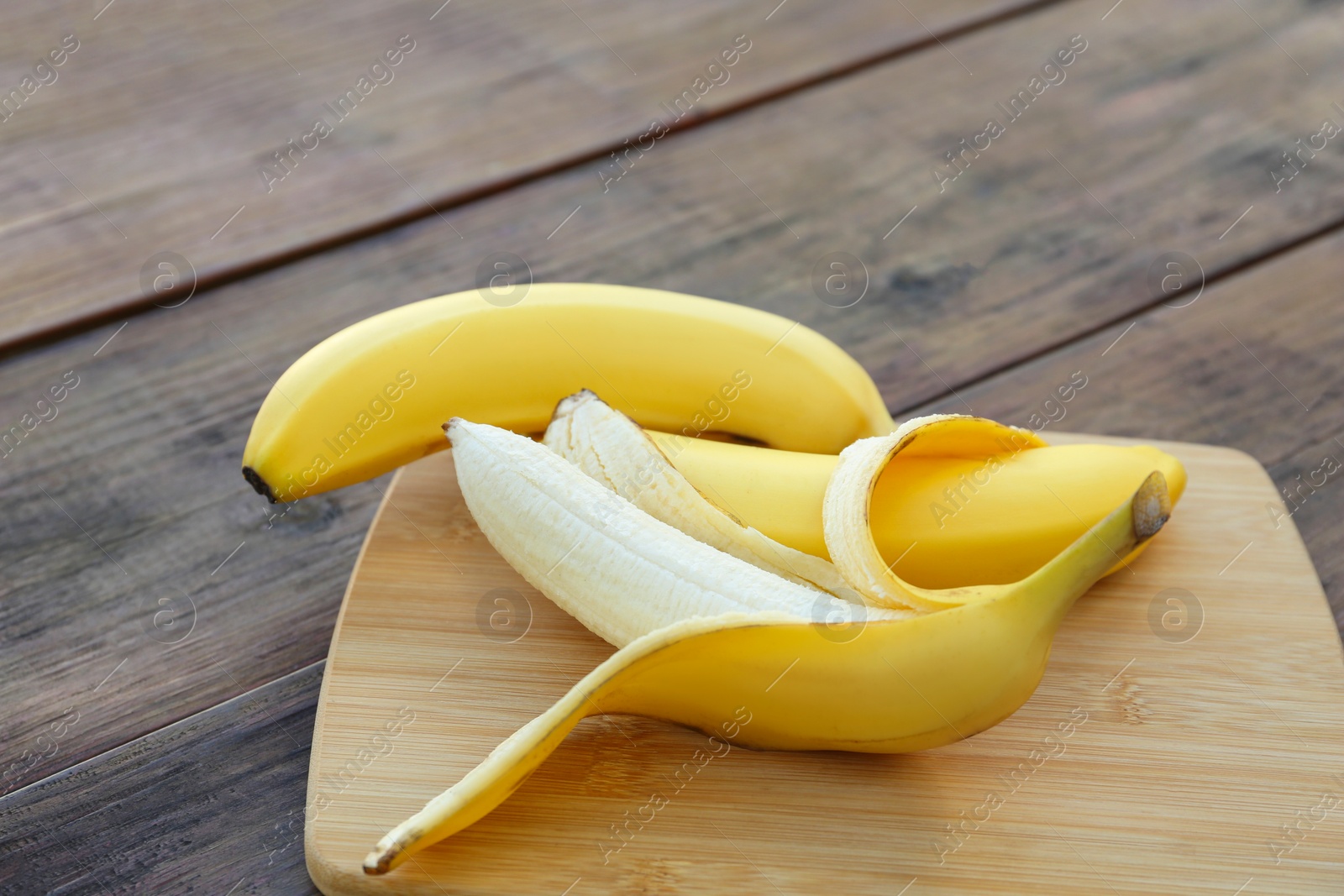 Photo of Delicious yellow bananas on wooden table, closeup