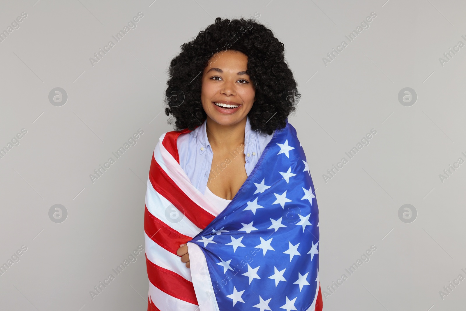 Photo of 4th of July - Independence Day of USA. Happy woman with American flag on light grey background