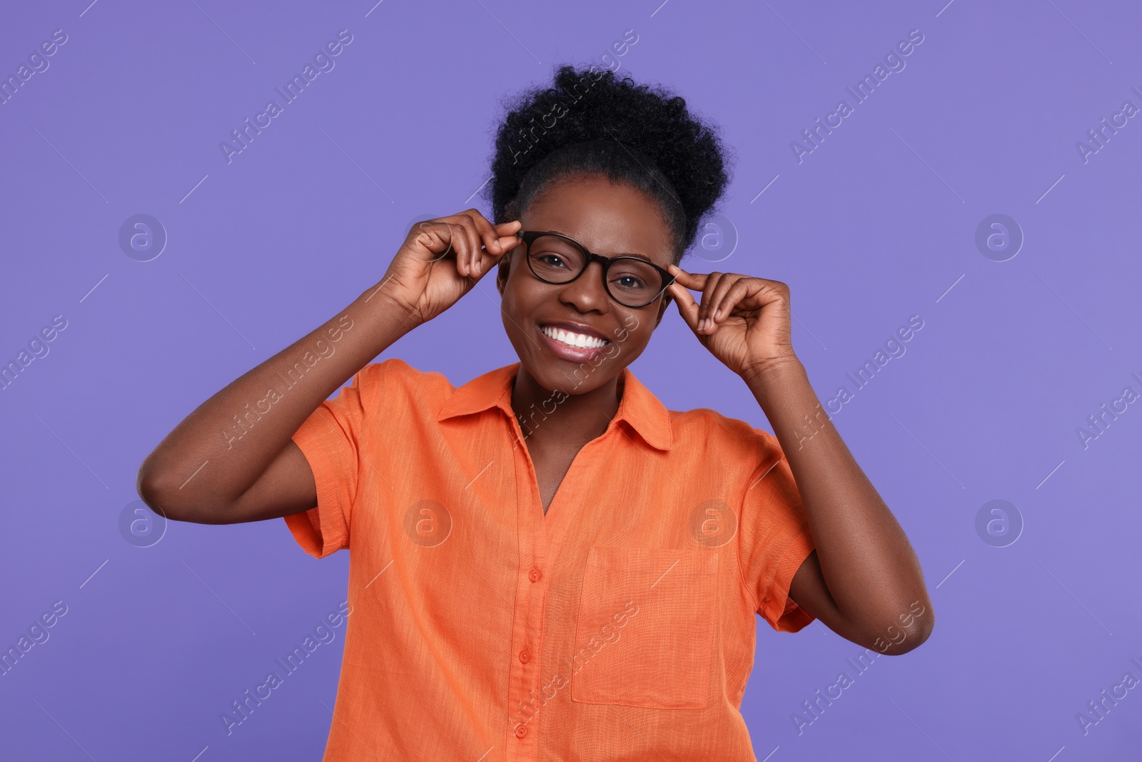 Photo of Portrait of happy young woman in eyeglasses on purple background