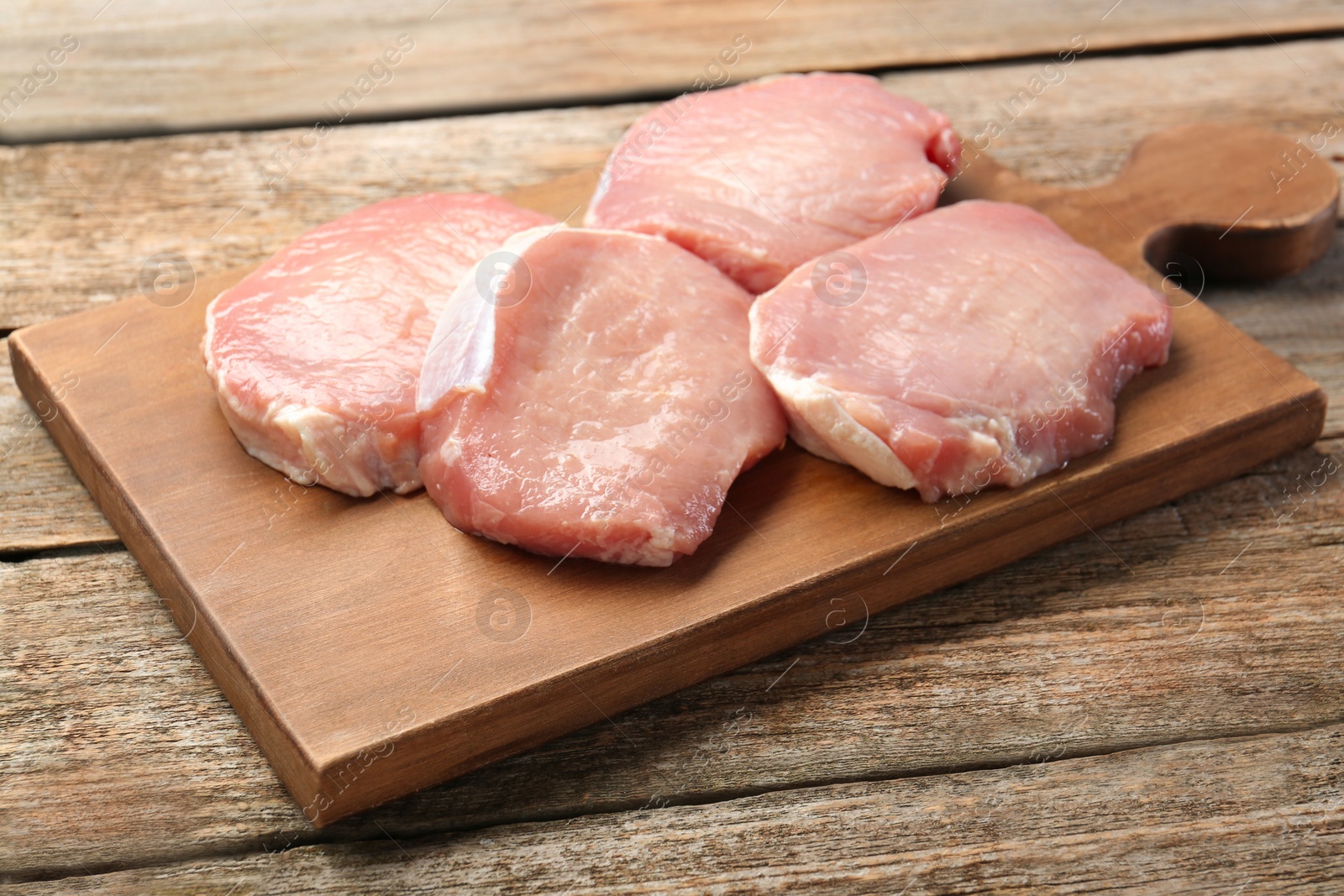 Photo of Pieces of raw pork meat on wooden table