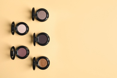 Photo of Flat lay composition with different eye shadows on color background. Space for text