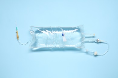 Photo of IV infusion set on light blue background, top view