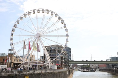 Photo of Cologne, Germany - August 28, 2022: Picturesque view of Ferris wheel in city near canal