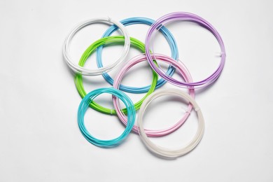 Photo of Colorful plastic filaments for 3D pen on white background, flat lay