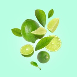 Image of Fresh lime fruits and green leaves falling on aquamarine background