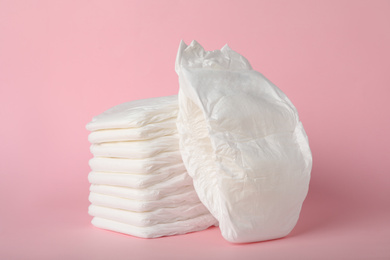 Photo of Stack of baby diapers on pink background