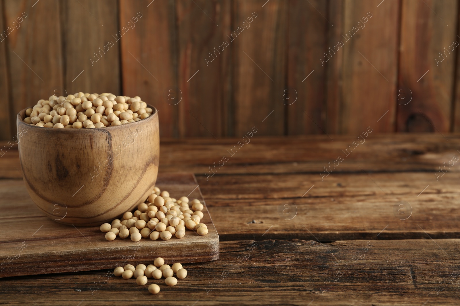 Photo of Soy in bowl on wooden table, space for text