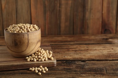 Soy in bowl on wooden table, space for text