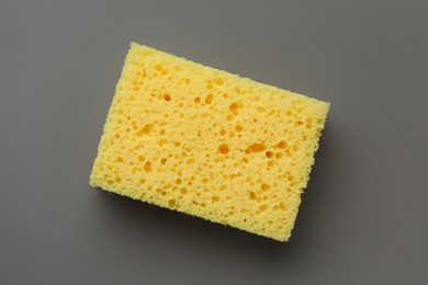 New yellow sponge on grey background, top view