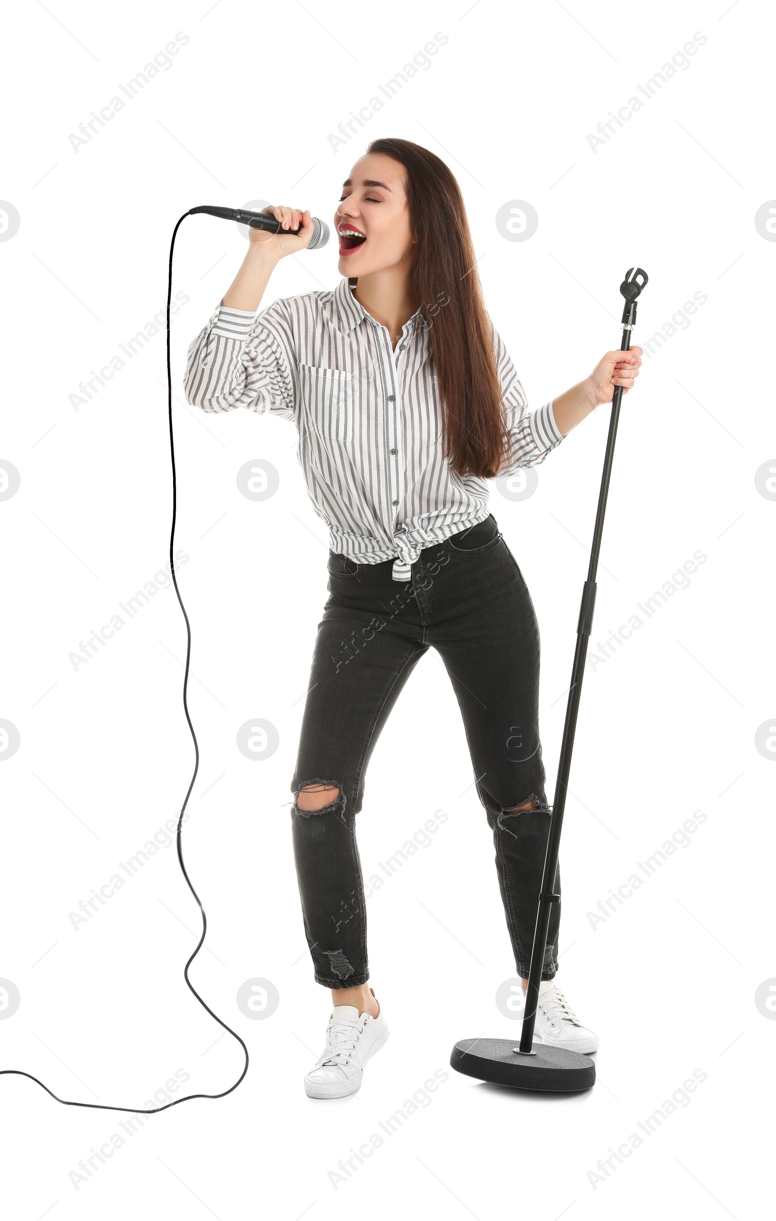 Photo of Young woman in casual clothes singing with microphone on white background