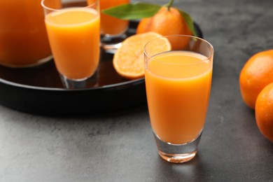 Delicious tangerine liqueur and fresh fruits on grey table, closeup