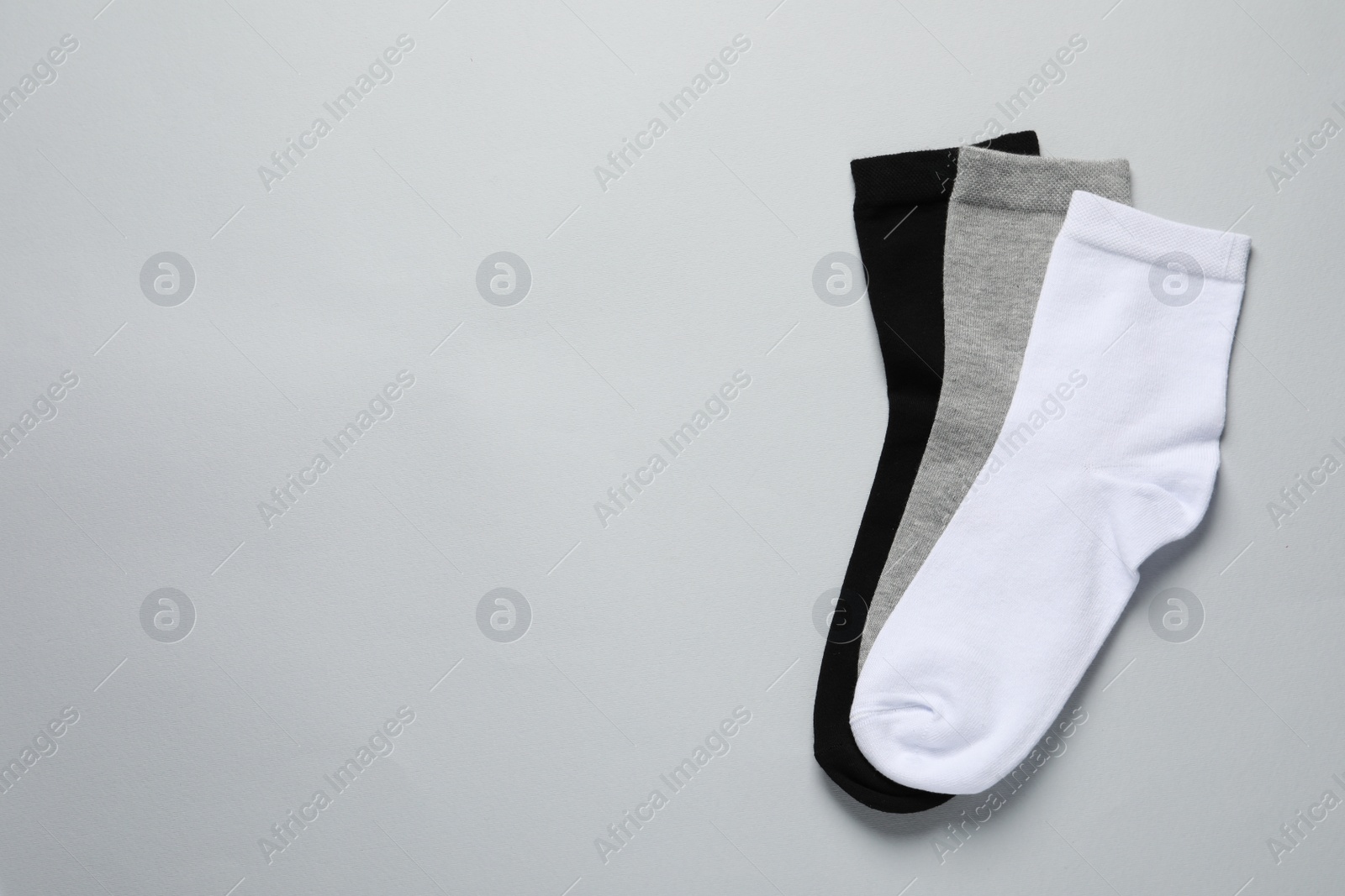 Photo of Different socks on light grey background, flat lay. Space for text