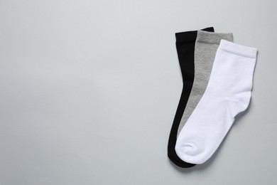 Photo of Different socks on light grey background, flat lay. Space for text