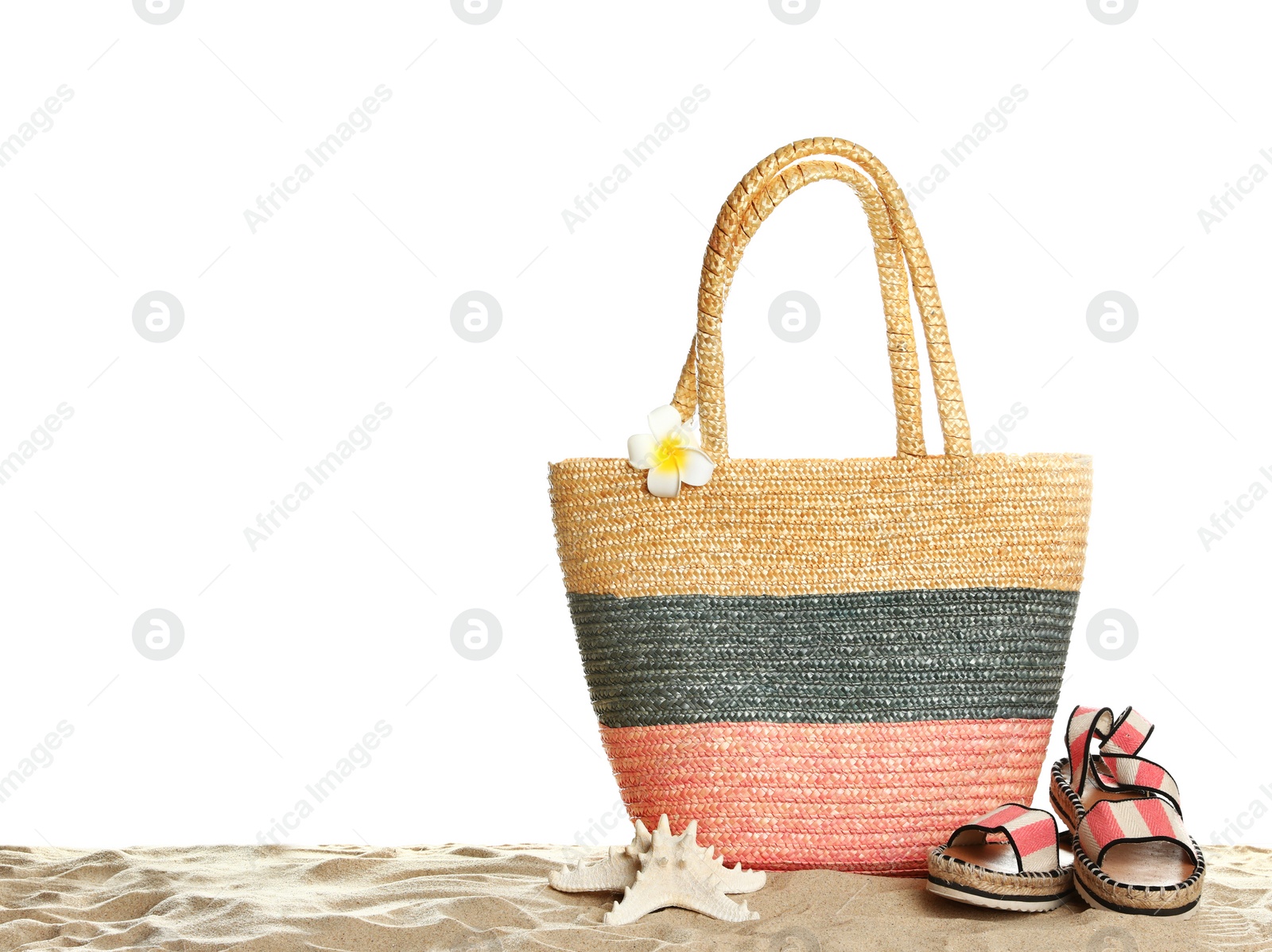 Photo of Wicker bag and beach accessories on sand against white background, space for text