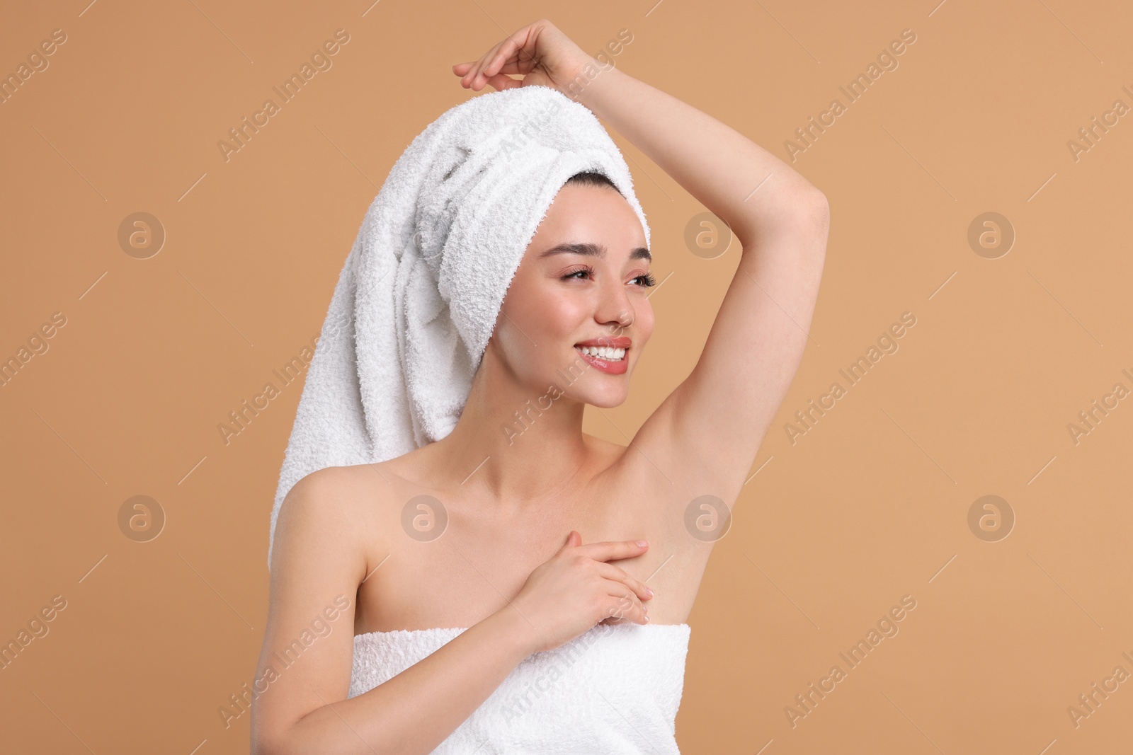 Photo of Beautiful woman showing armpit with smooth clean skin on beige background